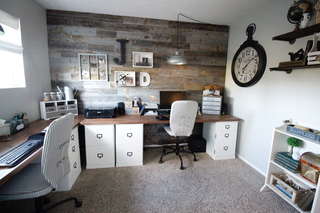 A home office with custom desks that use filing cabinets and are set against a modern wood wall. 