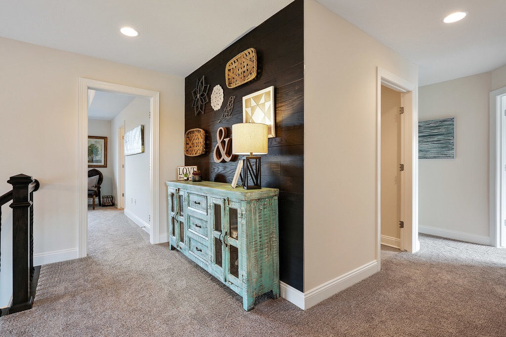 Dark colored timber panel walls add interest at top of staircase.