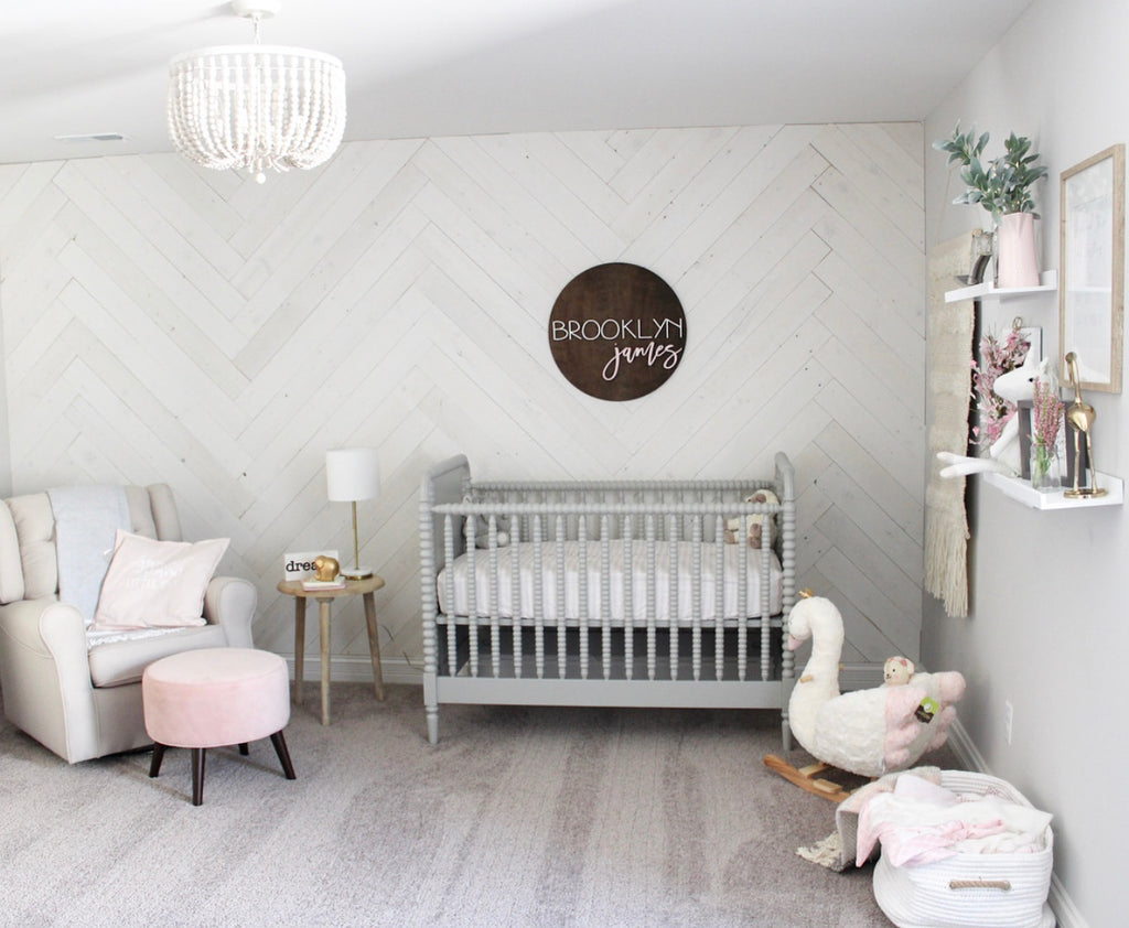 A nursery with interior wood plank walls in Hamptons done in a herringbone pattern.