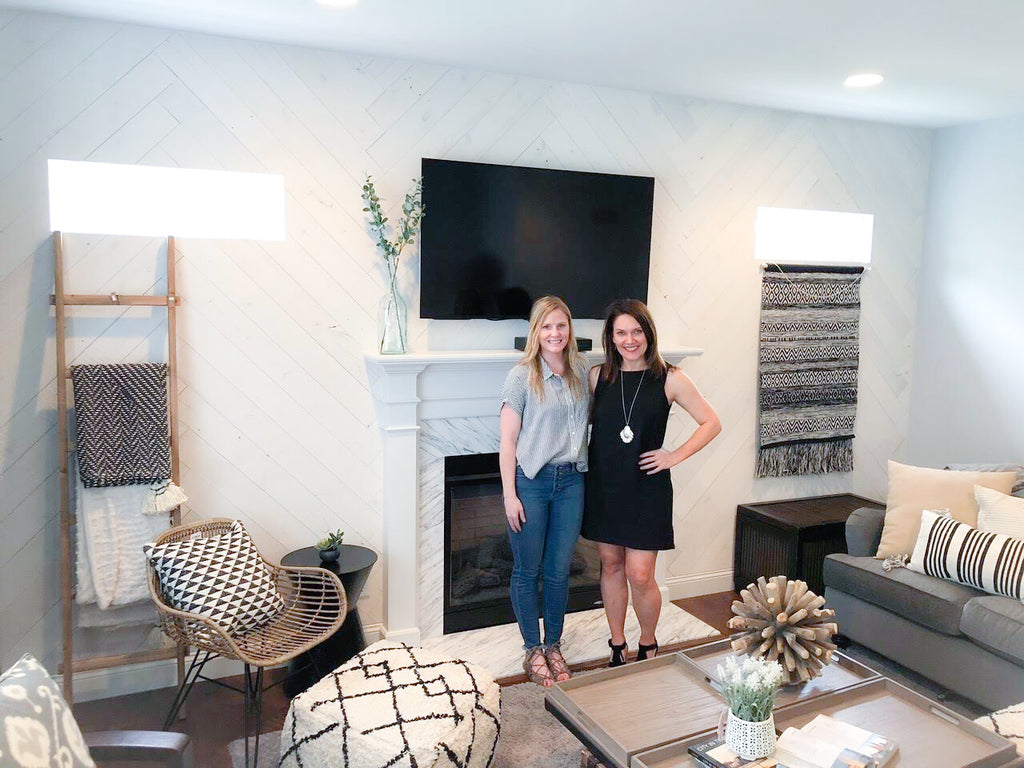 Sarah and Stephanie are standing in front of Sarah's Hamptons Reclaimed Wood Wall by Stikwood