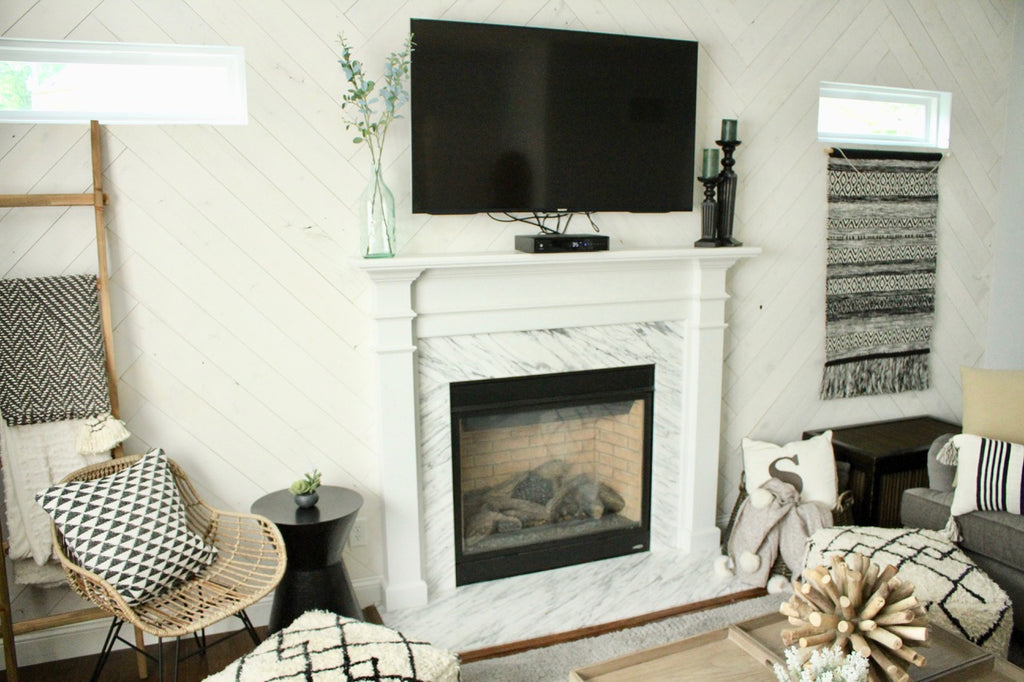 White wood plank fireplace wall done in herringbone pattern adds contemporary look to living room