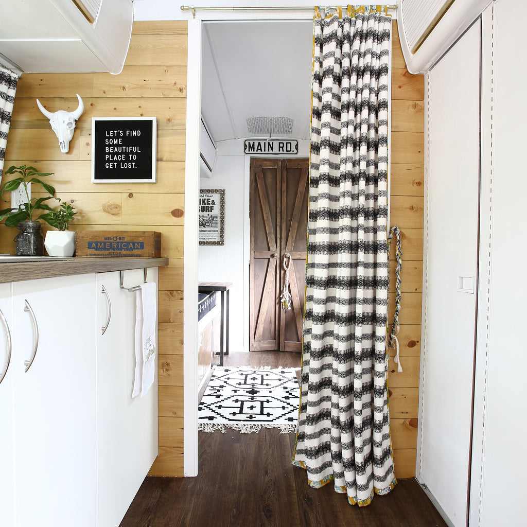 Golden Oak peel and stick shiplap creates a warmly hued wall in chic glamping trailer.