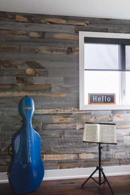 Weathered reclaimed timber wall creates backdrop for music room.