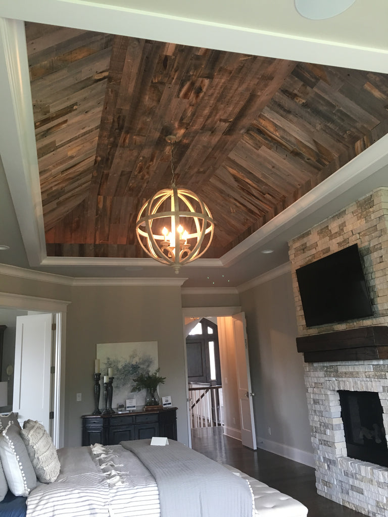 This reclaimed weathered wood vertical wood wall decor has added texture and dimension to an inverted ceiling.