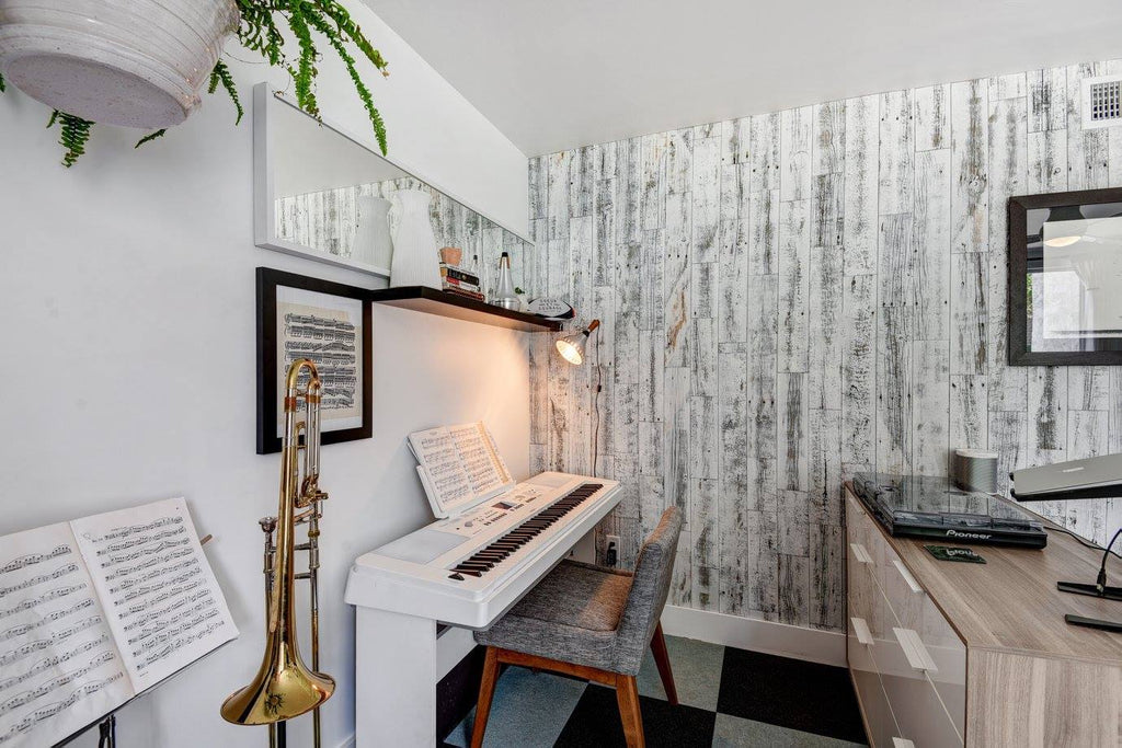 A home music room with a white stick on wood accent wall and 5-inch baseboards.
