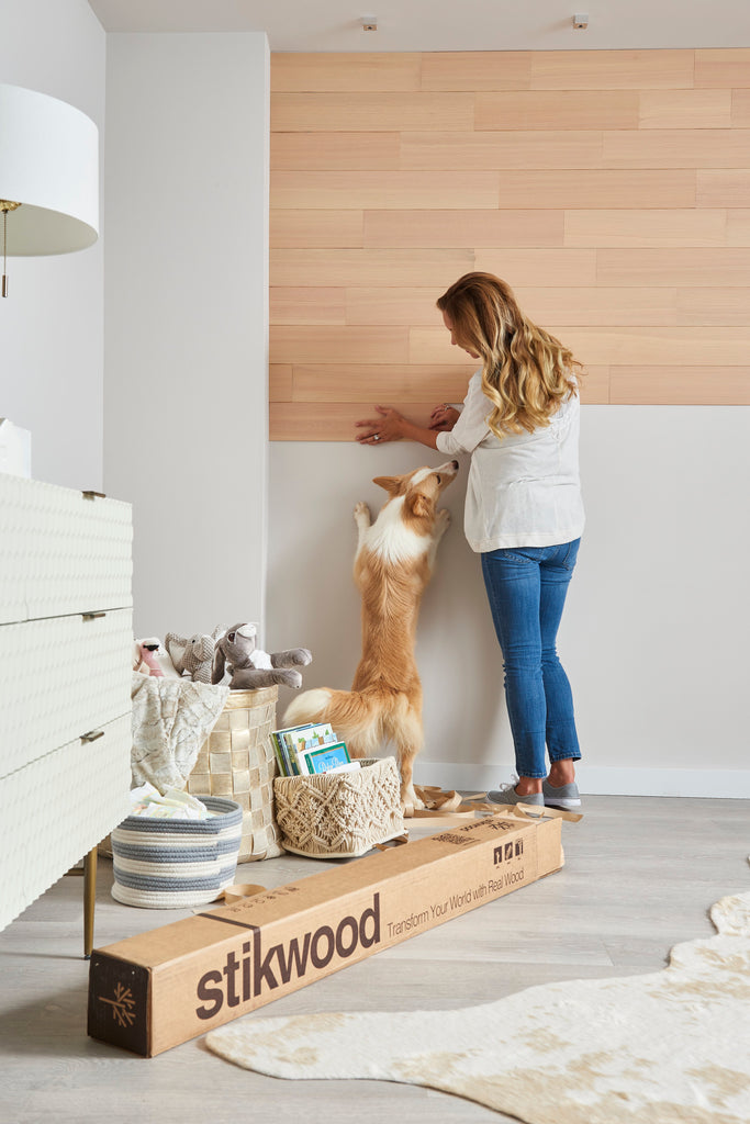 Pregnant woman installs timberwall peel and stick style paneling to a nursery wall.