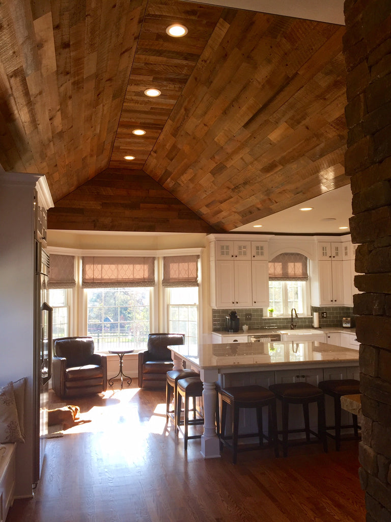 Wood planking for ceilings helps the coved ceiling mirror the wood floor in this cozy cabin kitchen.