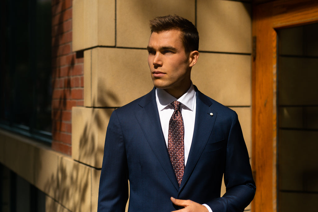 Men's style glossary - suit terms defined - photo of man in navy suit with white shirt and burgundy tie