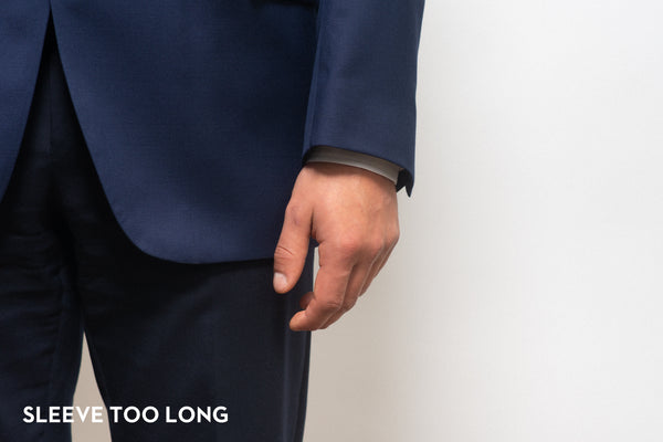 Suit sleeve that is too long covering the shirt cuff