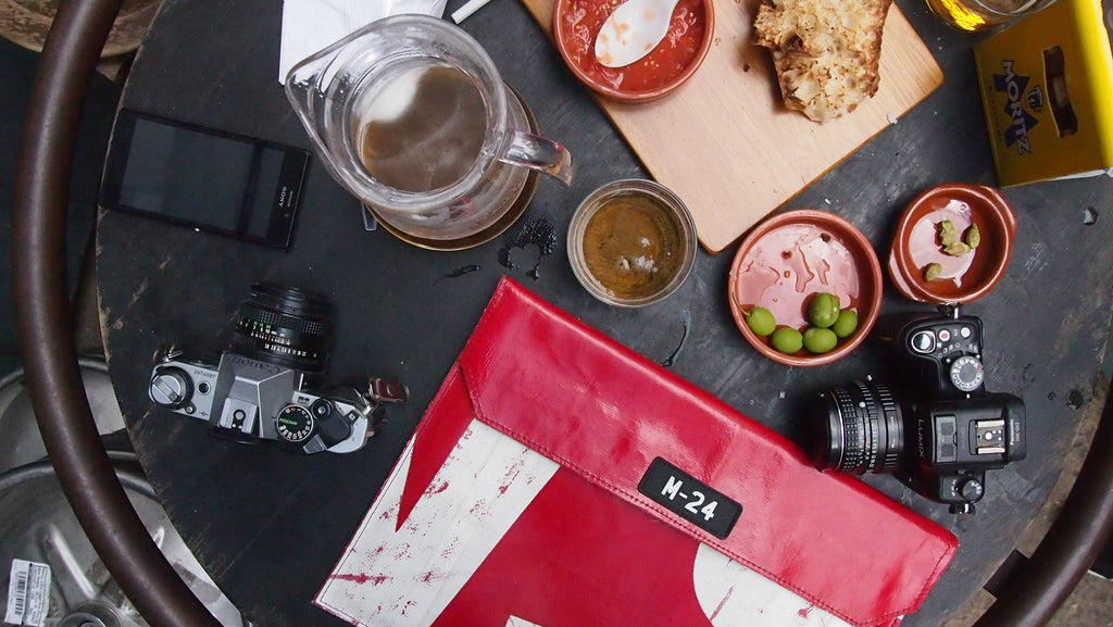 m24 upcycled tarpaulin macbook sleeve on a table with beer and snacks