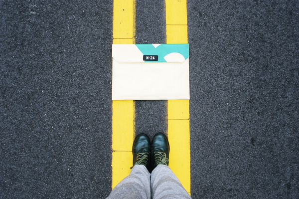 upcycled macbook sleeve on the road marked with double yellow lines. Modelled by sustainability chic