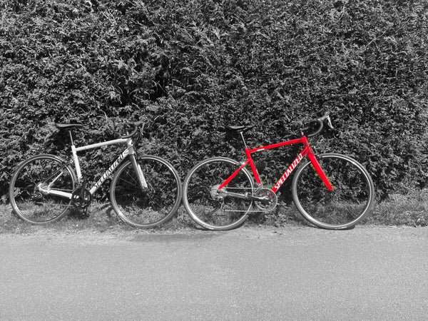 two specialized bikes on a hedge