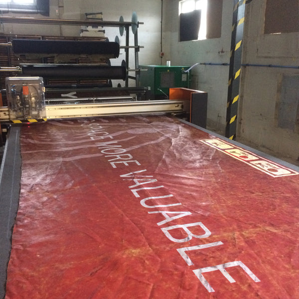 upcycled truck tarpaulin being cut on a laser cutting machine