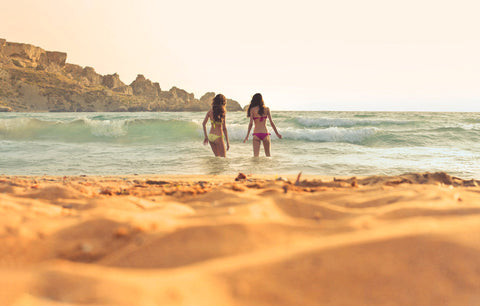 ragazze camminano sull'acqua in spiaggia