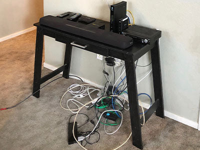 Close up of table with devices and messy cords on floor