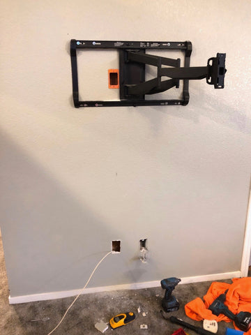 TV wall mount on wall without TV, power outlet box and cables 