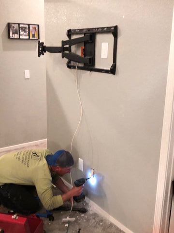 TV wall mount on wall without TV, man drilling hole to move power outlet 