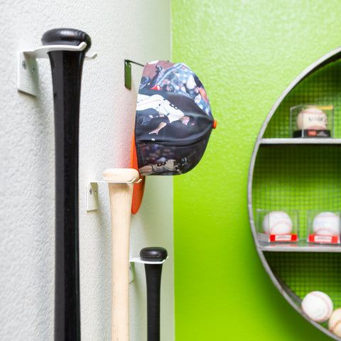 Three baseball bats wall mounted with white HIDEit VBat Mounts