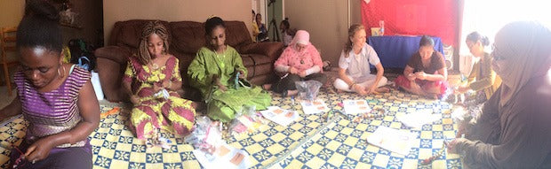 Female artisans sitting on a floor making products for GAIA