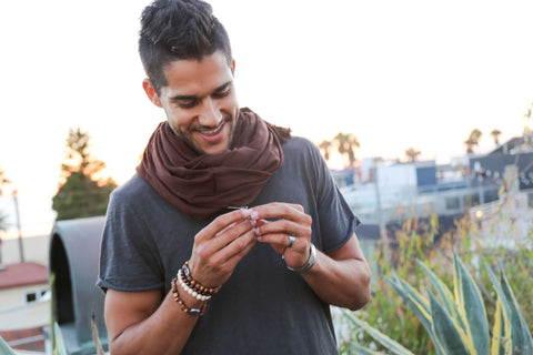 smiling well dressed man wearing many bracelets