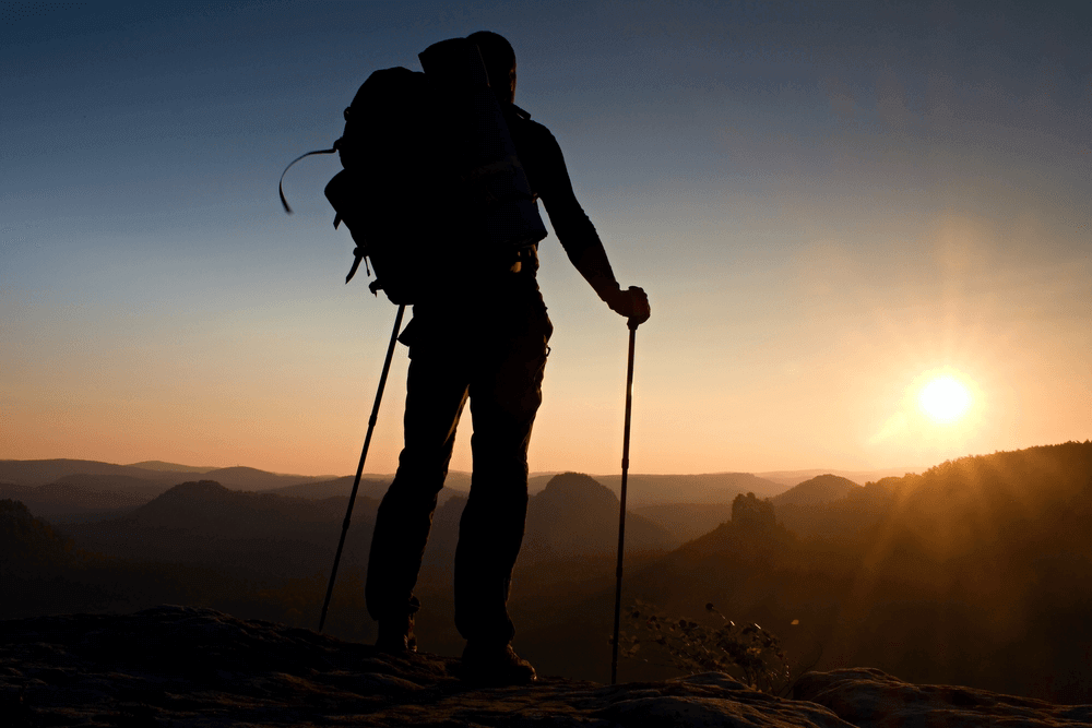 man with trekking poles on mountain