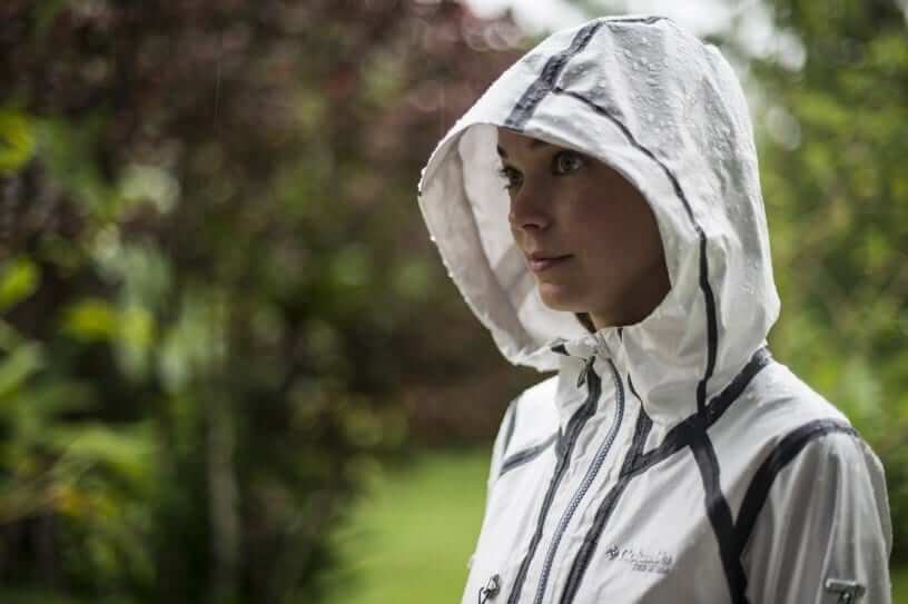 Woman wearing a white Columbia rain jacket in the rain.