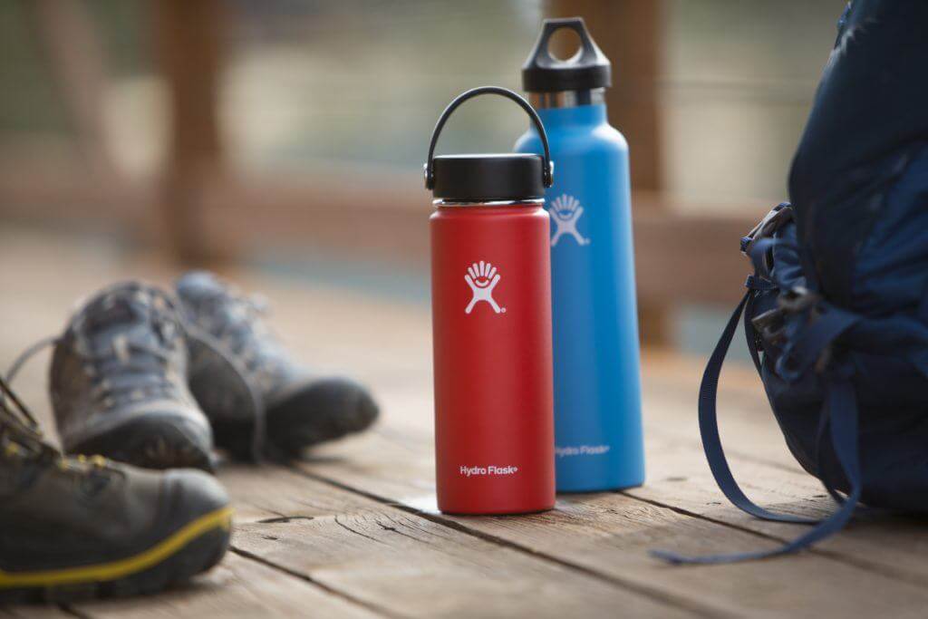 Hydro Flask stainless steel water bottles sitting on wooden deck planks