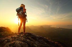 Woman with backpack on top of a mountain 