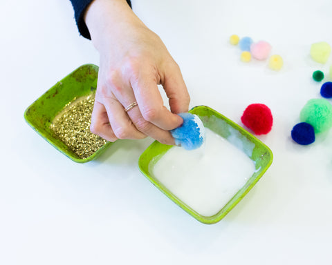 dipping pom poms into white glue (one side only)