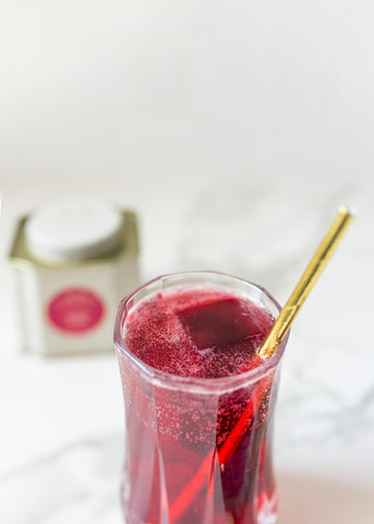 crimson berry iced tea spritzer in glass with straw
