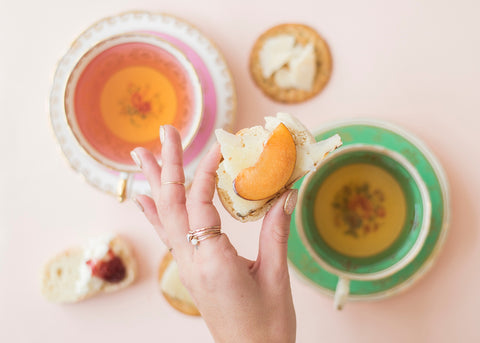 hand holding crisp over tea cups