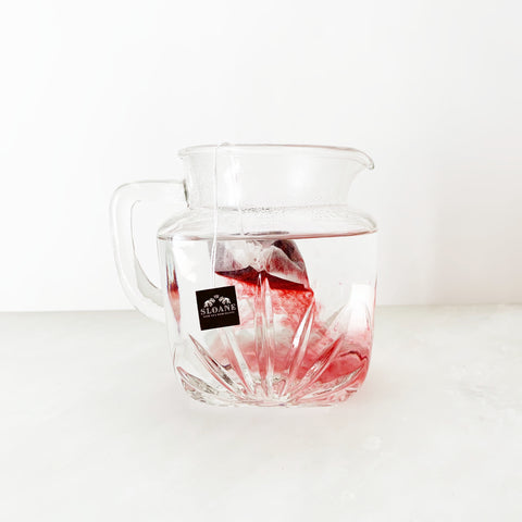 Sloane filter of crimson berry in pitcher of hot water