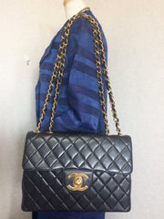 Vintage CHANEL black lamb leather large, jumbo shoulder bag with a big golden CC closure and chain strap. 2.55 classic purse
