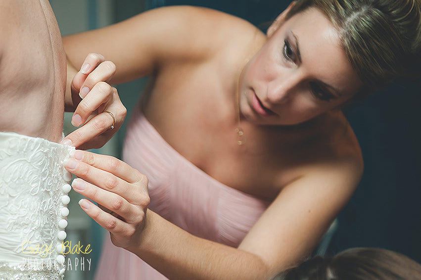 photgraphing weddings - bridesmaid helping with dress