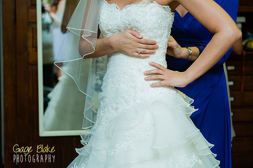 Important wedding shots - bride putting on dress