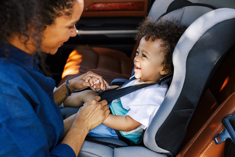 Mom putting baby in carseat
