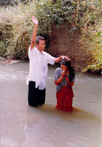 Rev. Paul Ibobi bautizando a una nueva hermana en Cristo.
