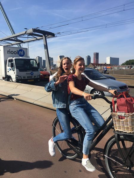 Happy Dutch girls riding their bikes over the Rotterdam bridge, photo by Susan Stokhof