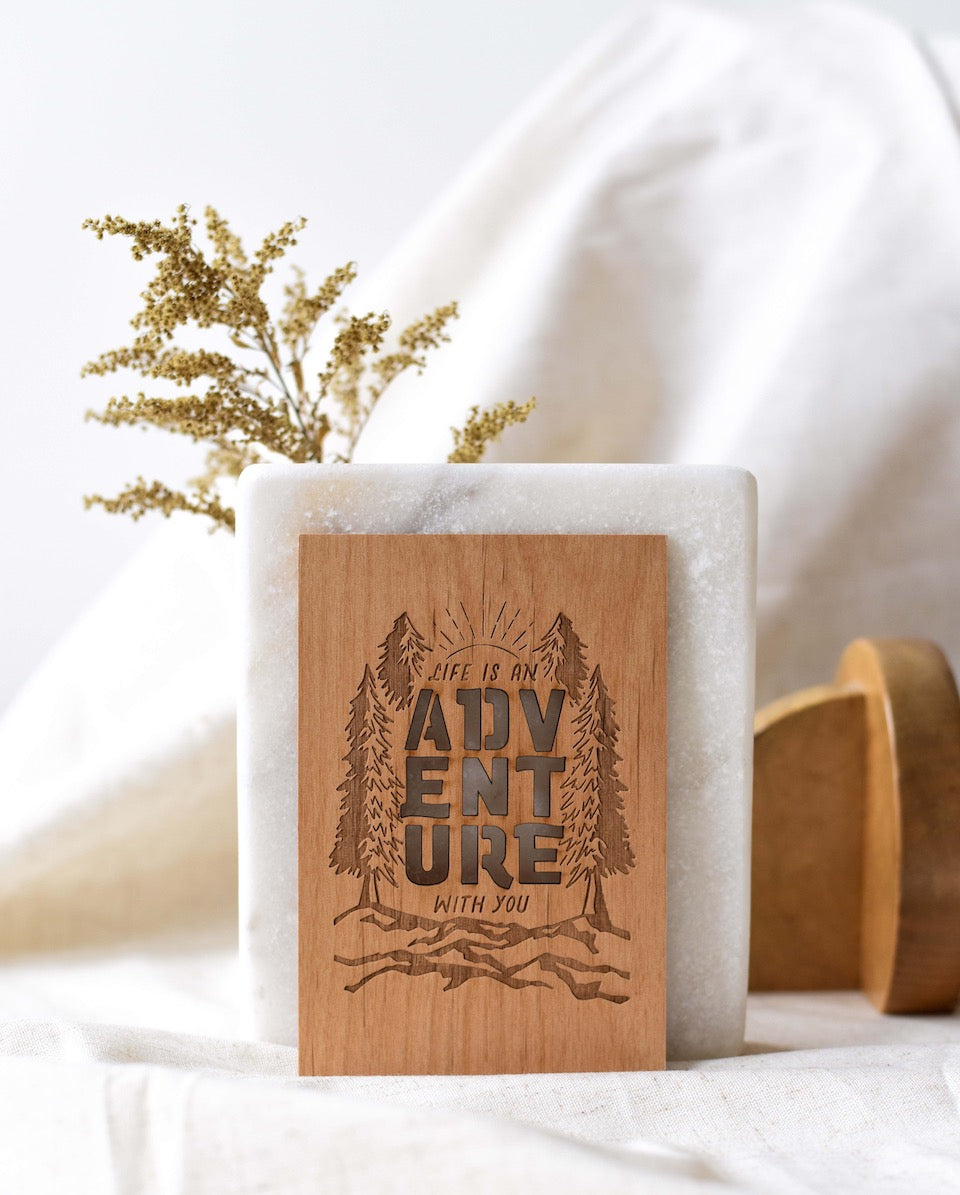 engraved wooden card with "Adventure"