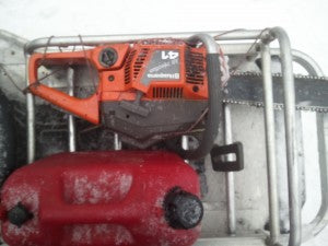 Chainsaw and mixed gas in snowmobile rack