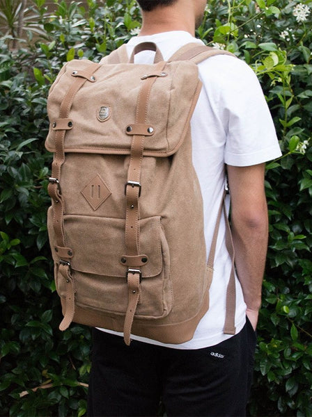Side view of the light brown canvas daypack worn by stylish man