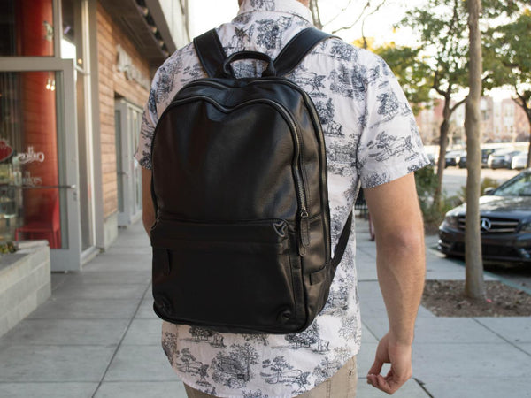 Man wearing the unisex black leather backpack by Serbags