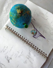Sketchbook of hat shapes with felted globe