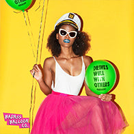 Woman with captain hat and a pink ballerina skirt on a yellow background holding green balloons 