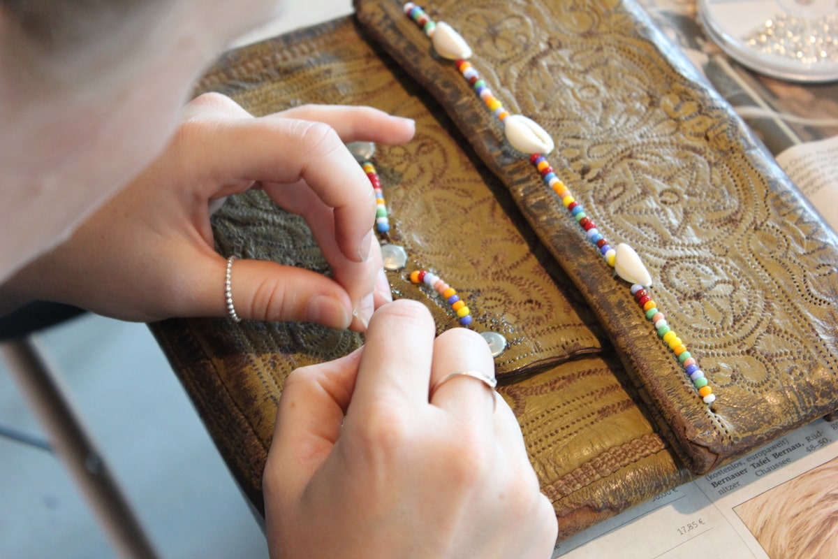 close up of someone customizing a vintage berber bag