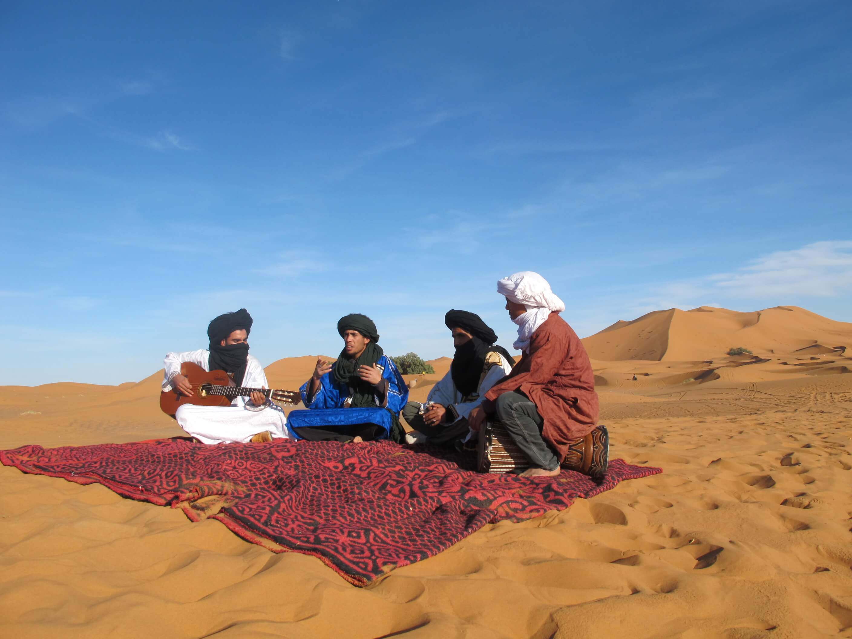 people playing instruments in the moroccan desert