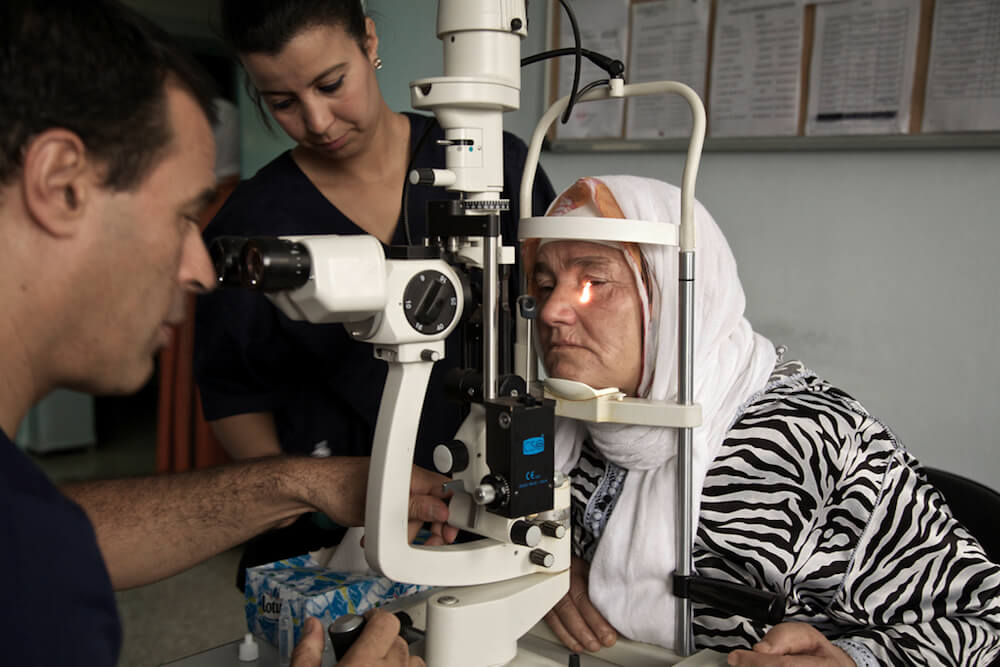 dr raiss looking at the eyes of a patient