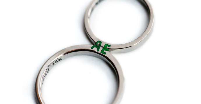 silver ring set with green initials