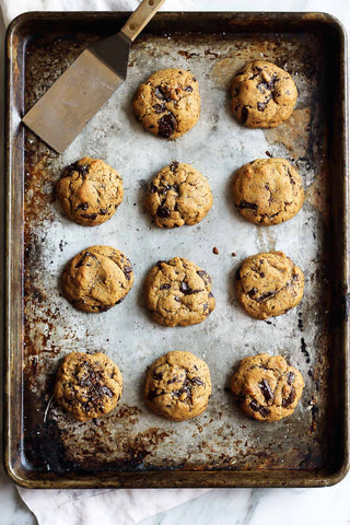 nut-free chocolate chip cookies viewed from above on baking tray with metal spatula in corner