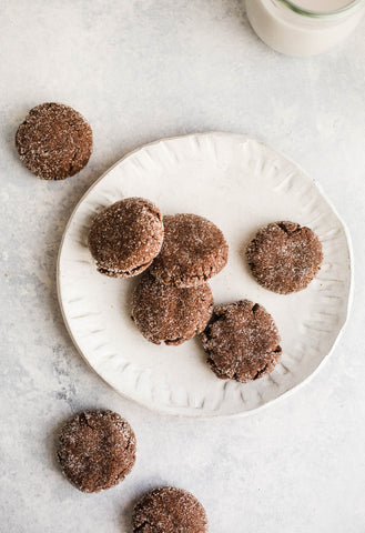 cookies made with cacao on a white plate with some on white table